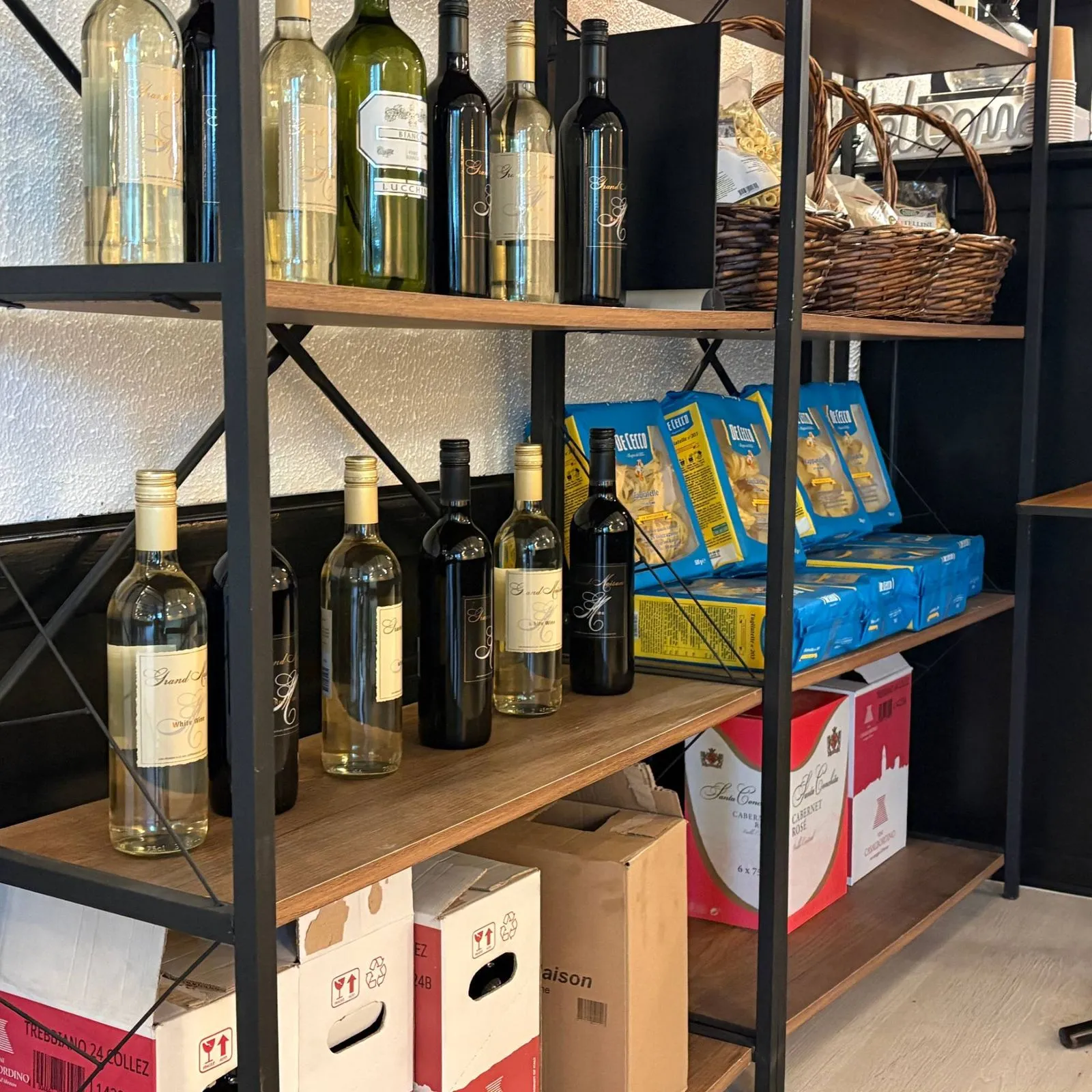 Hylder med vin og italiensk pasta hos Bella Pizza